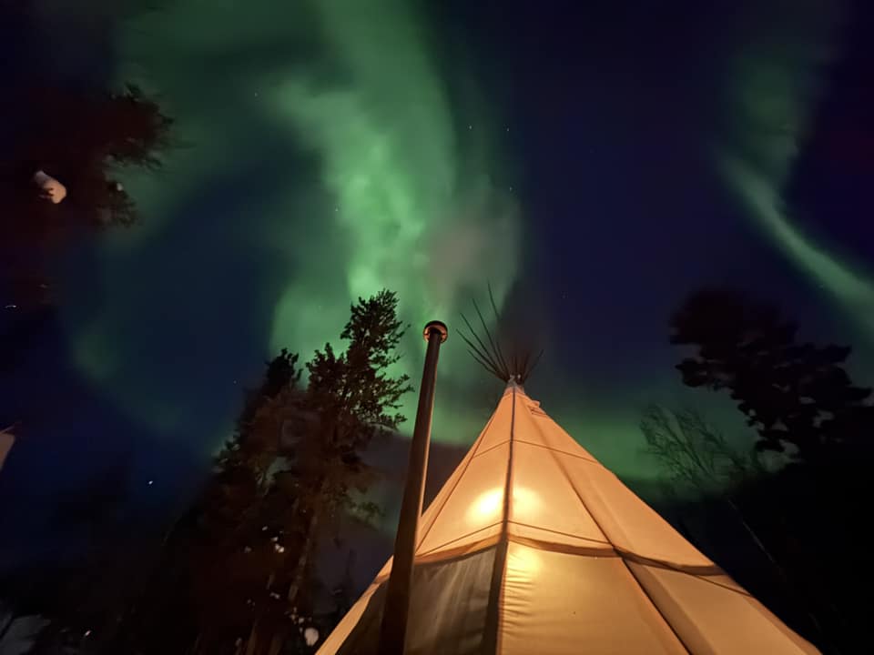 Photo of a teepee under the Aurora